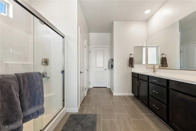 full bath featuring recessed lighting, baseboards, a shower stall, and vanity