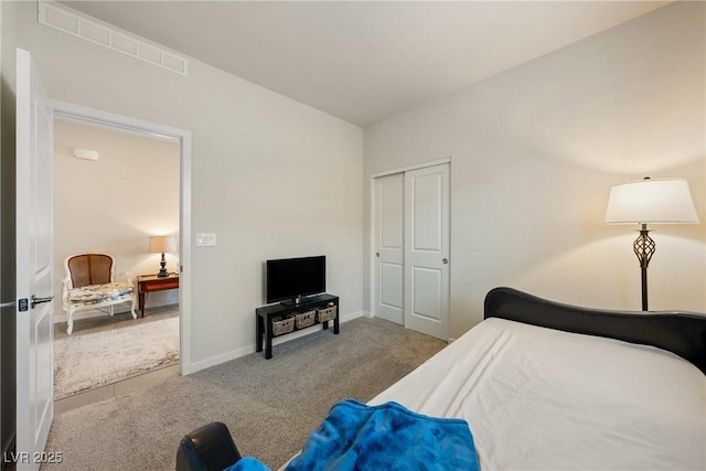 carpeted bedroom with a closet, visible vents, and baseboards