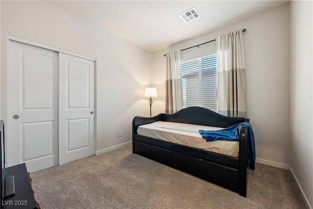 carpeted bedroom featuring baseboards, visible vents, and a closet