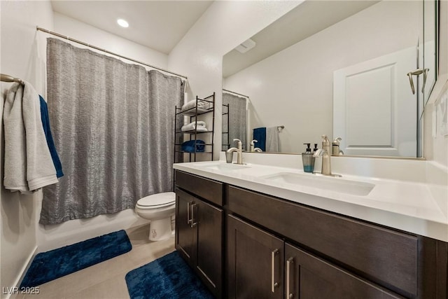 bathroom with tile patterned flooring, a sink, toilet, and double vanity