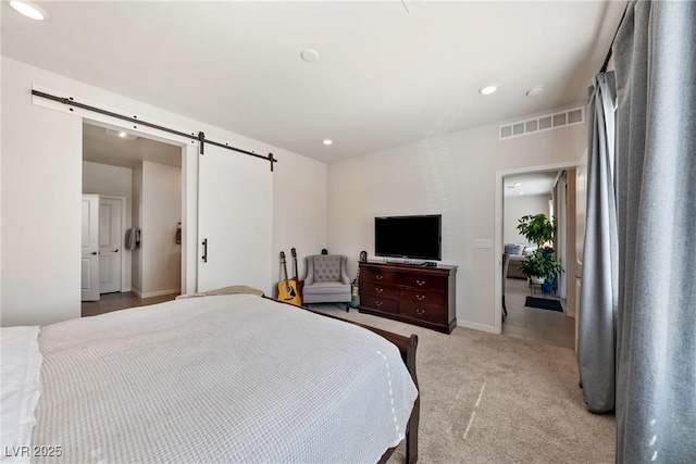 bedroom with light carpet, a barn door, visible vents, baseboards, and recessed lighting