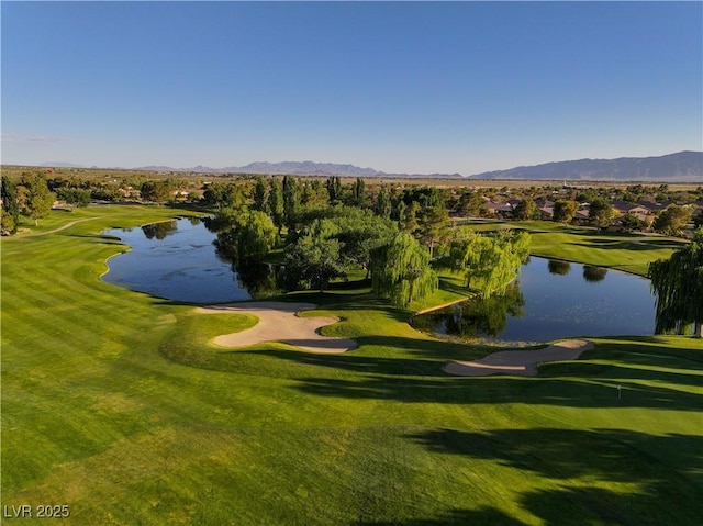 surrounding community with a yard, golf course view, and a water and mountain view