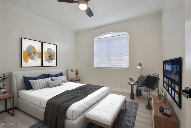 bedroom with light wood finished floors, baseboards, and ceiling fan