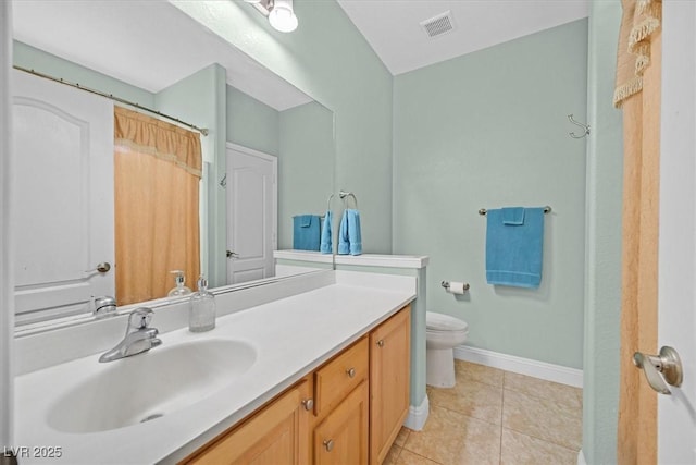 bathroom with visible vents, toilet, vanity, tile patterned flooring, and baseboards