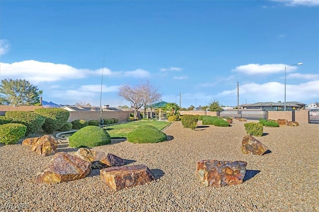 view of property's community featuring fence and a yard