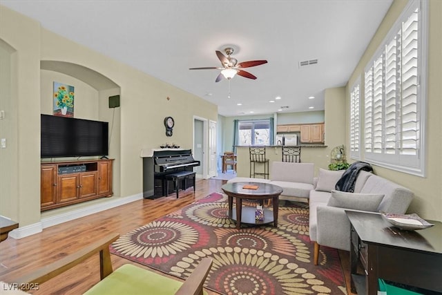 living room featuring ceiling fan, recessed lighting, visible vents, baseboards, and light wood-style floors