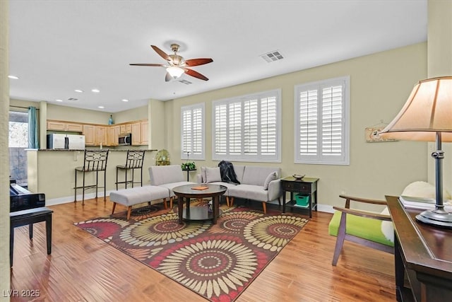 living room with a healthy amount of sunlight, visible vents, and light wood finished floors