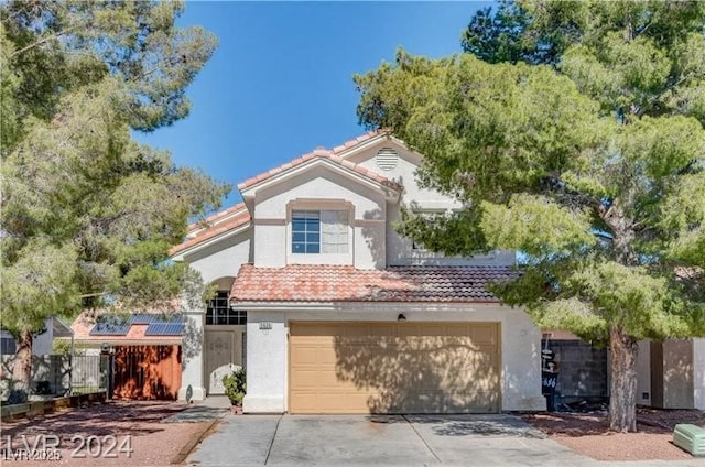 view of front of home featuring driveway, a garage, a tile roof, fence, and stucco siding