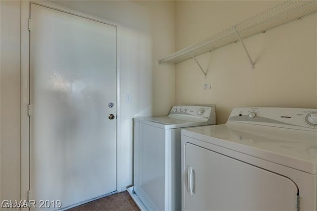 clothes washing area featuring laundry area, separate washer and dryer, and dark tile patterned flooring