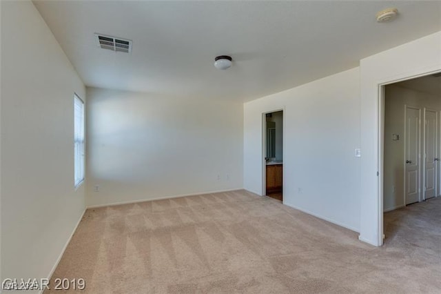 unfurnished room with visible vents and carpet flooring