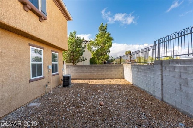 view of yard with central air condition unit and a fenced backyard