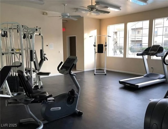 gym featuring baseboards and a ceiling fan