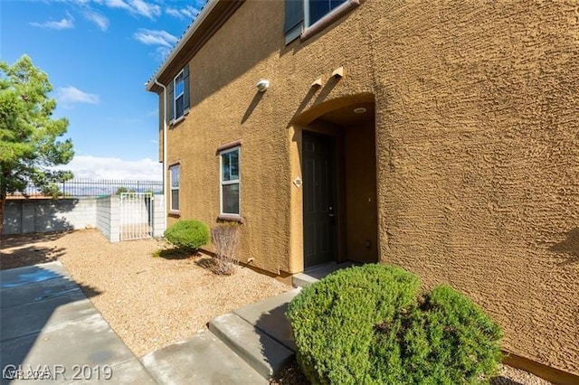 view of property exterior featuring fence and stucco siding