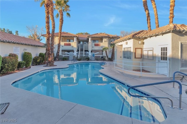 pool featuring a patio area and a residential view