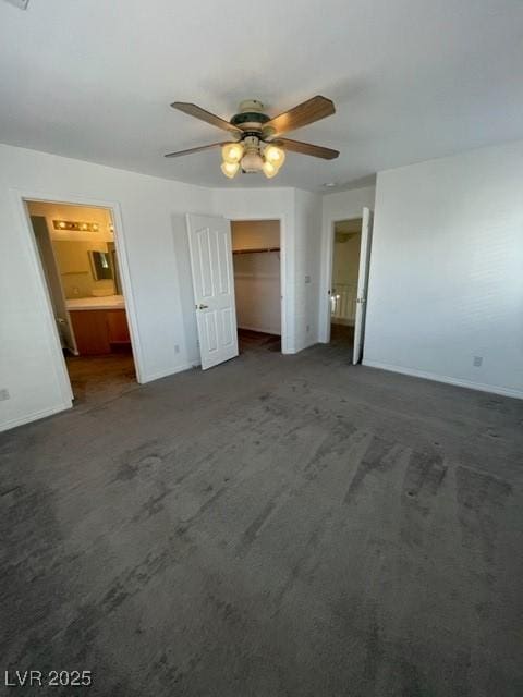 unfurnished bedroom featuring carpet, connected bathroom, a ceiling fan, and baseboards