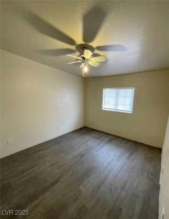 spare room with a textured ceiling, wood finished floors, and a ceiling fan