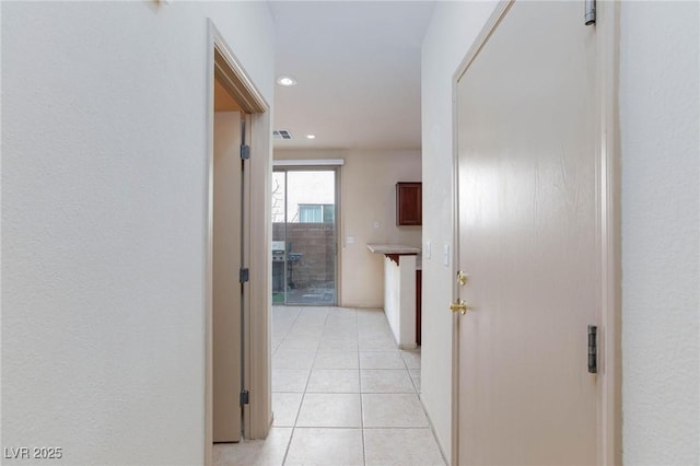 hall featuring light tile patterned floors, visible vents, and recessed lighting