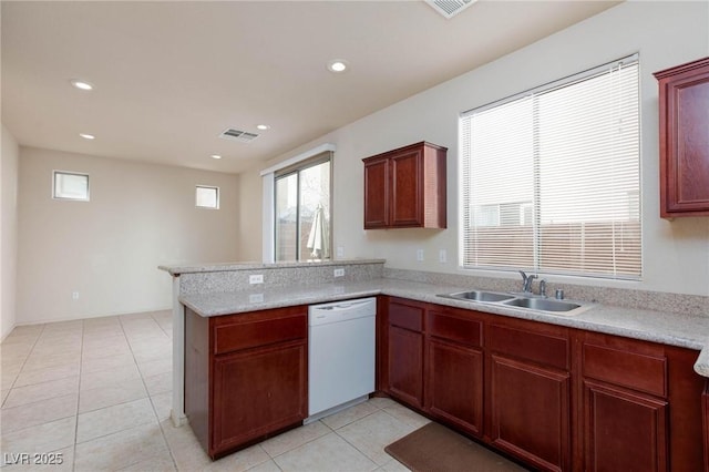 kitchen with visible vents, light countertops, white dishwasher, a sink, and a peninsula