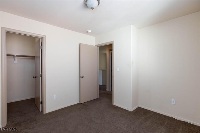 unfurnished bedroom with carpet, a closet, and baseboards