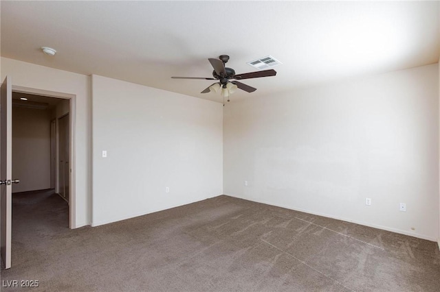 spare room featuring carpet floors, ceiling fan, and visible vents