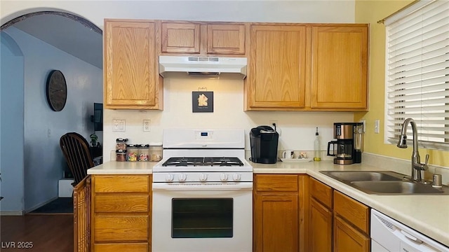 kitchen featuring white appliances, light countertops, a sink, and under cabinet range hood