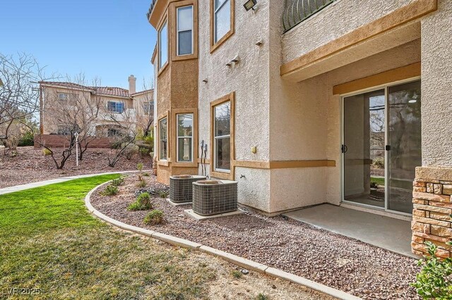 exterior space with central AC unit and stucco siding