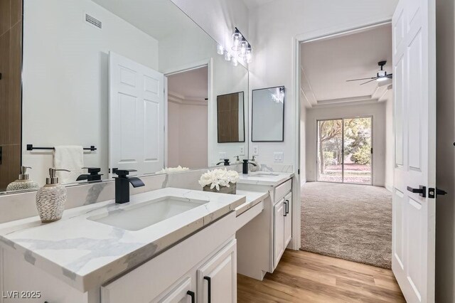 bathroom featuring ceiling fan, visible vents, wood finished floors, and vanity