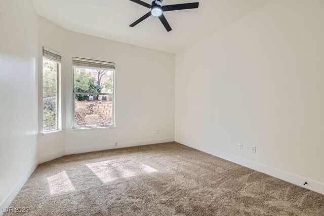 spare room featuring a ceiling fan, carpet, and baseboards