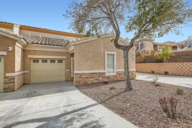 view of front of property with fence, concrete driveway, stucco siding, a garage, and stone siding