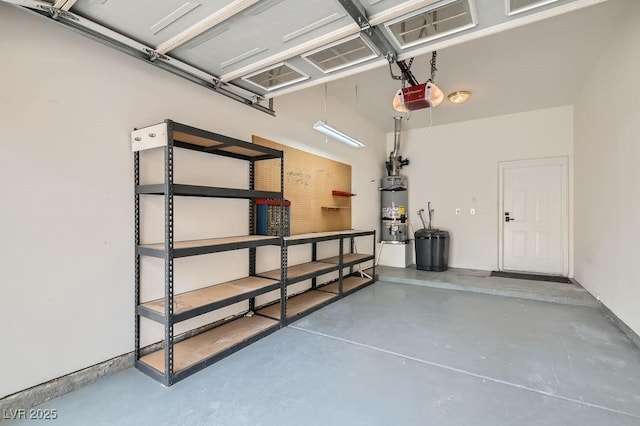 garage featuring strapped water heater and a garage door opener