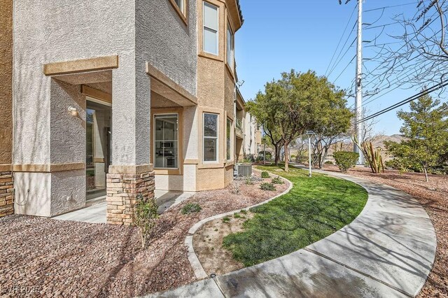 view of property exterior with stucco siding and cooling unit