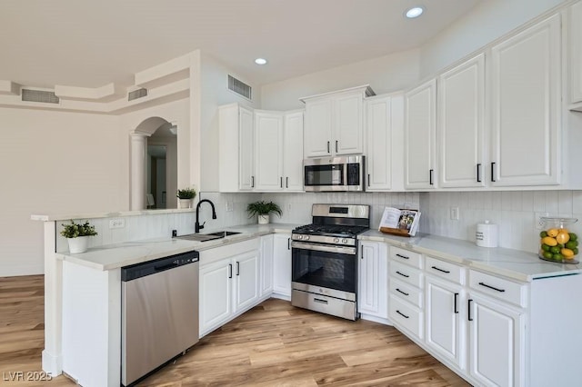 kitchen with a sink, visible vents, appliances with stainless steel finishes, and white cabinetry