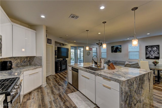 kitchen featuring visible vents, white cabinets, appliances with stainless steel finishes, dark wood-style flooring, and a sink