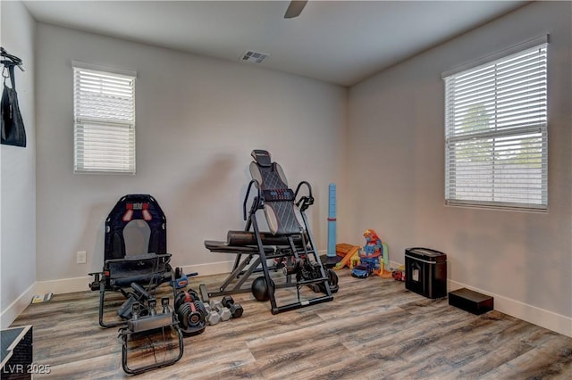 exercise room with visible vents, baseboards, and wood finished floors