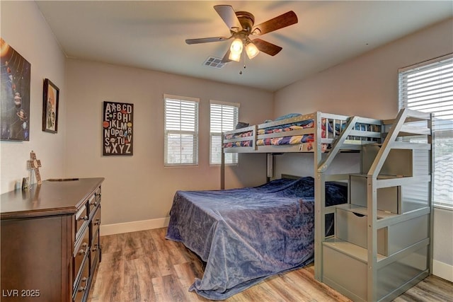 bedroom with light wood-style floors, visible vents, ceiling fan, and baseboards