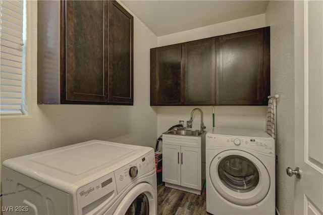 clothes washing area featuring dark wood-type flooring, washing machine and dryer, cabinet space, and a sink