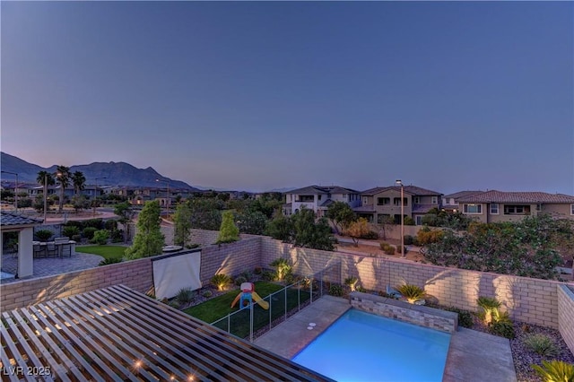 view of swimming pool with a fenced in pool, a patio, a mountain view, a residential view, and a fenced backyard