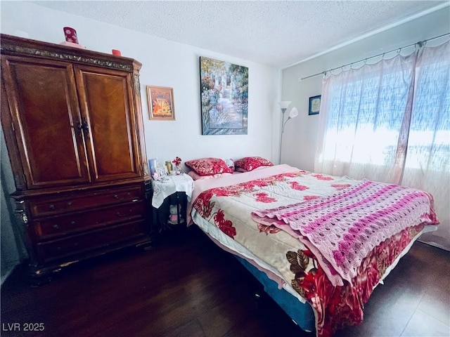 bedroom with dark wood-style floors and a textured ceiling