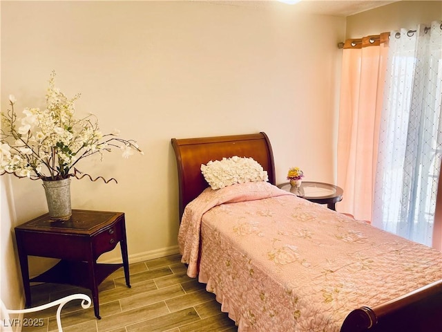 bedroom featuring wood tiled floor and baseboards