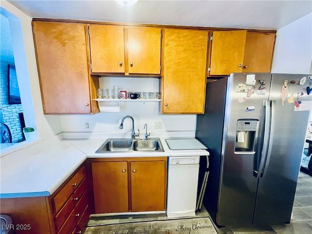 kitchen featuring light countertops, brown cabinetry, a sink, dishwasher, and stainless steel fridge with ice dispenser