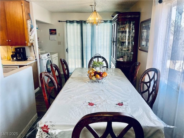 dining room featuring a textured ceiling, baseboards, and separate washer and dryer