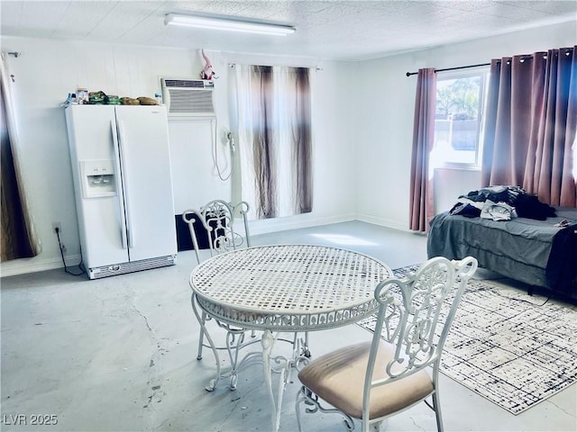 interior space featuring a wall unit AC, concrete floors, and a textured ceiling