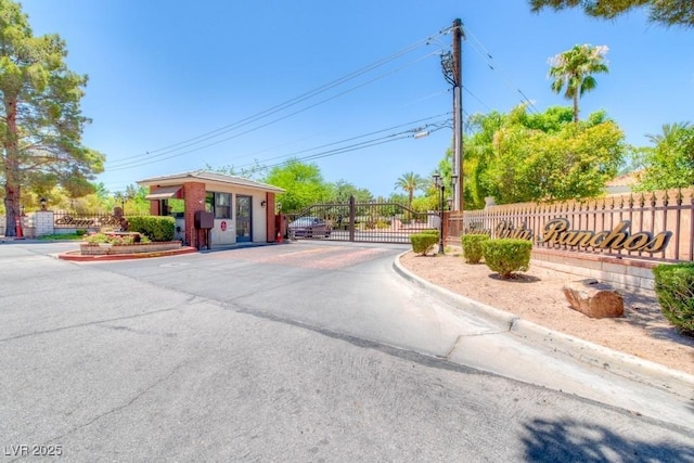 view of road with a gate, curbs, and a gated entry