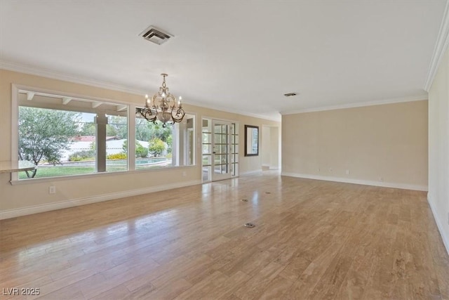 empty room featuring light wood-style floors, visible vents, crown molding, and baseboards