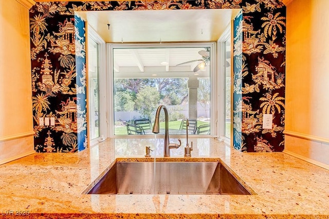 interior details with a sink and light stone countertops