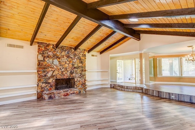 unfurnished living room featuring a chandelier, visible vents, a fireplace, and wood finished floors