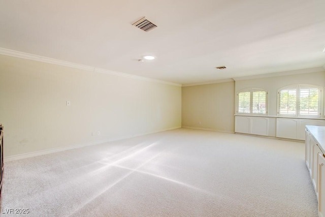 spare room with baseboards, visible vents, crown molding, and light colored carpet