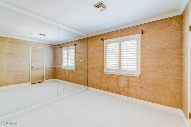 unfurnished bedroom with ornamental molding, visible vents, and carpet flooring