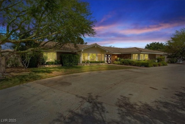 single story home with driveway and a tile roof