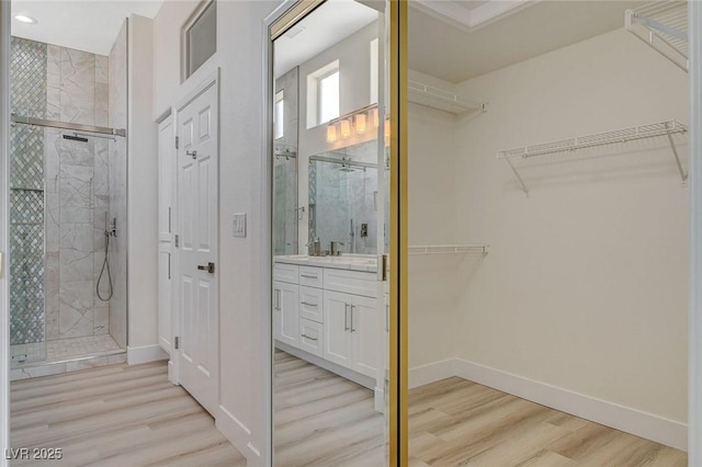 walk in closet with light wood finished floors